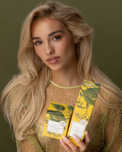 Shampoing et Après Shampoing Tilleul et Bouleau Nordique avec leurs boîte, tenus par une femme blonde avec de très jolis cheveux longs